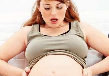 Беременная смотрит на живот